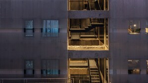 Un edificio de varios pisos con escaleras exteriores y balcones.