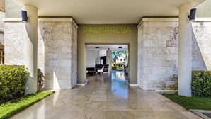Ein Hotel Eingangsbereich mit Marmorboden, einer Rezeption und einem Pool im Hintergrund.