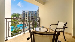 Ein Balkon mit Blick auf einen Pool und ein Hotelgebäude.