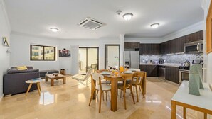 Eine moderne Wohnung mit Wohnzimmer, Essbereich und Küche.
