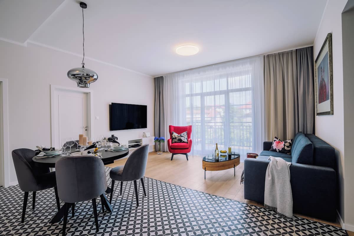 Appartamento Comfort | Area soggiorno | TV a schermo piatto 115 cm con canali via cavo, pavimenti riscaldati