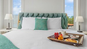 A hotel room with a large bed, two bedside tables, a tray with breakfast, and a view of the sea. - NEW 6 Bedroom Villa 2min Eagle Beach Palm Beach (Noord)