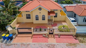Un quartier résidentiel où les maisons se distinguent par leurs toits recouverts de tuiles rouges et où un bâtiment central présente une façade jaune.