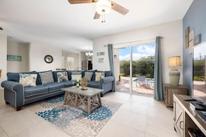 Relax in this inviting living space with a sofa, coffee table, and stunning pool views.