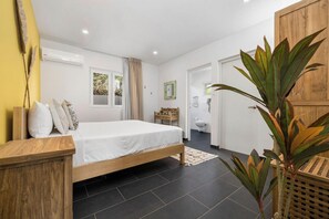Relax in this serene bedroom with a comfortable bed, large window, and bathroom access.