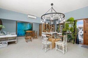 Cozy living area with a round table, comfortable chairs, and a beautiful abstract painting.