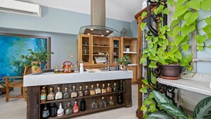 A kitchen with wooden cabinets, a built-in wine rack, and various kitchen items. - 2BR Private Pool Outdoordining Amazing Gardens (Noord)