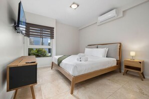 Relax in a clean and uncluttered space with a comfortable bed, desk, and large window.
