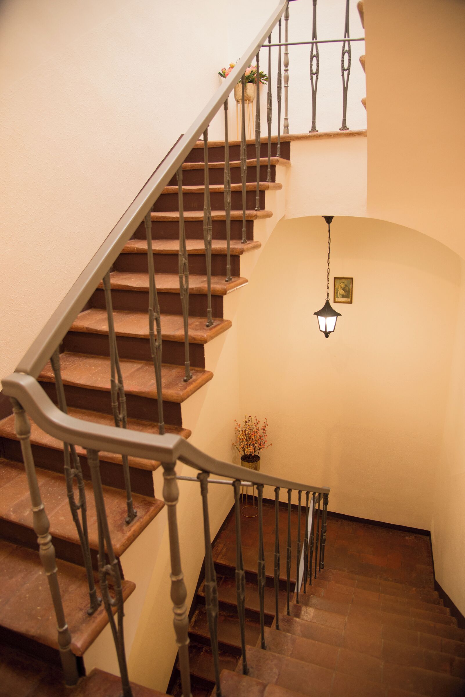 A staircase with wooden steps and metal railings, leading to an upper floor.