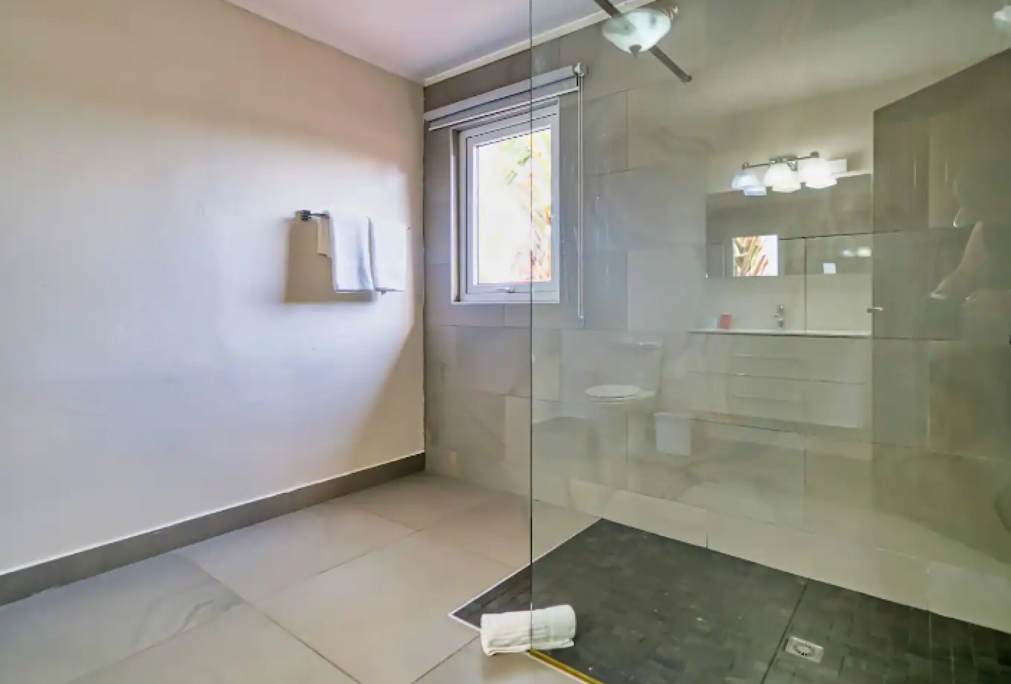Une salle de bain moderne avec une douche à parois de verre, des toilettes et un lavabo.