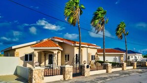 A residential area with houses featuring red-tiled roofs and stone pillars. - Spacious 6BR Villa w Pool Close2beach Sleeps 16 (Noord)