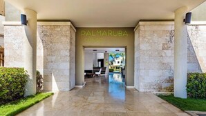 Entrada de um hotel com uma placa que diz 'PALMARUBA CONDO'.