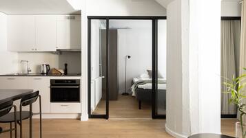 A modern apartment with a kitchen, dining area, and a bedroom.