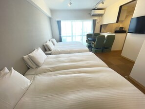 A hotel room with two beds, a desk with a chair, a TV, and a microwave. - BiBi Hotel Cosmos Shintoshin (Naha)