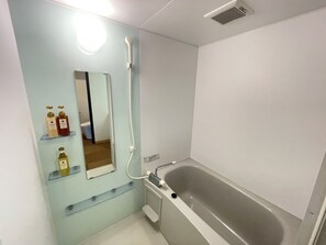 Familie vierpersoonskamer | Badkamer | Een haardroger, pantoffels, een bidet, handdoeken