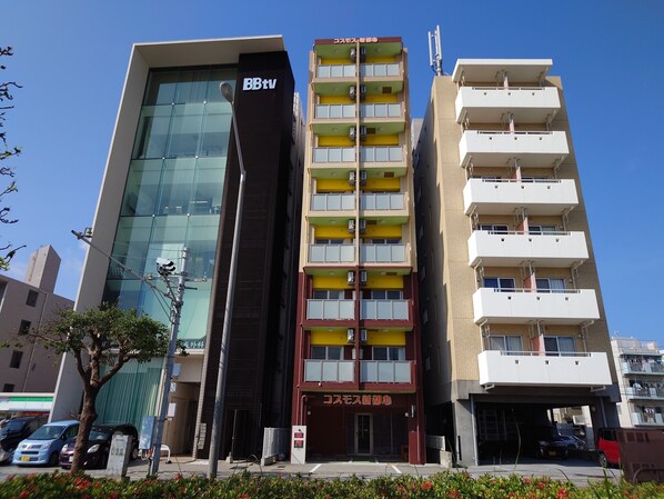 A multi-story building with a modern glass facade and a sign for B8tv. - BiBi Hotel Cosmos Shintoshin (Naha)