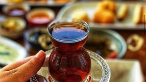 A table with various dishes and a glass of tea. - Cunda Ada Kızı Otel (Ayvalik)