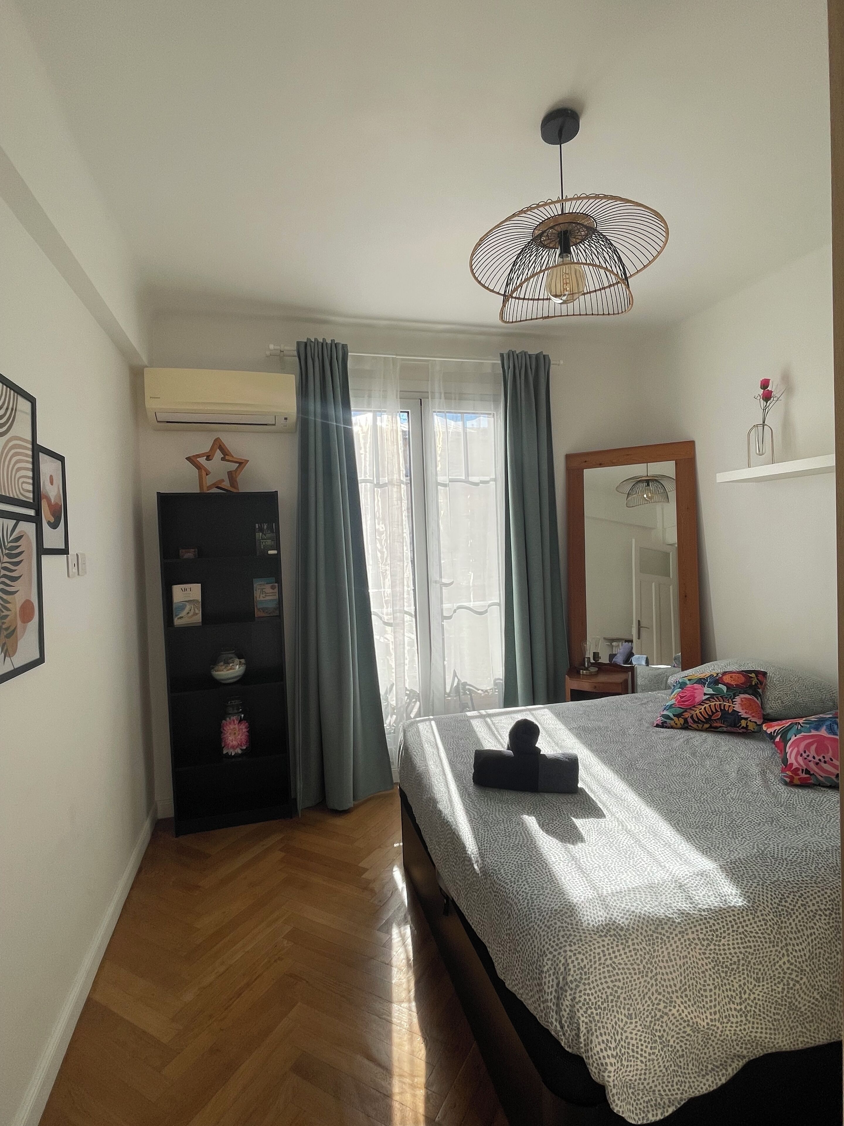 Ein Schlafzimmer mit Bett, Kommode, Spiegel und Deckenventilator.