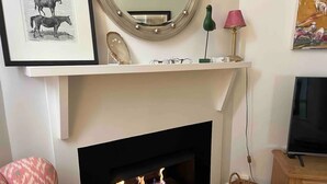 A living room with a fireplace, a television, and a shelf with decorative items. - No. 4 on Bolton
 (Wagga Wagga)
