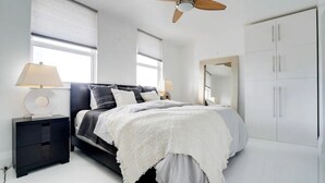 A bedroom with a bed, bedside tables, a ceiling fan, and a wardrobe. - Chic Penthouse: 3BR | Pool | Gym| 2 Parking Spots (Miami)