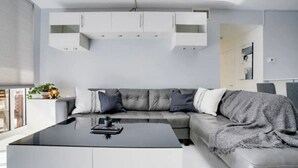 A modern living room with a grey sofa, white cabinets, and a black coffee table. - Chic Penthouse: 3BR | Pool | Gym| 2 Parking Spots (Miami)