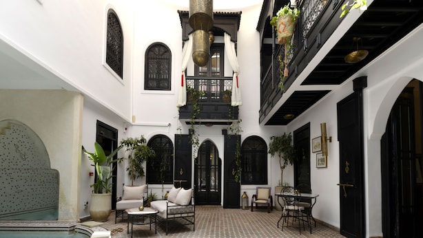 A courtyard with a pool, seating areas, and potted plants. - Riad Spa Le Secret de Zoraida (Marrakech)
