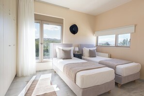 A bedroom with two beds, a large window, and a view of the outdoors.