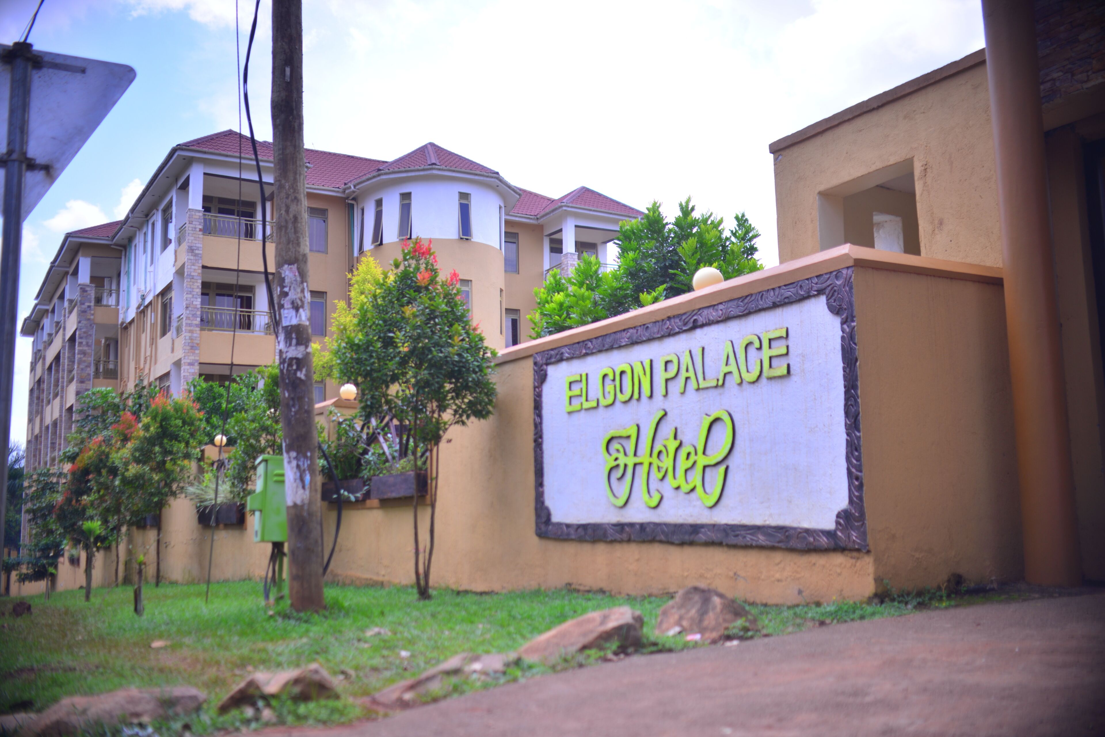 A sign for Elgon Palace Hotel with a clear view of the building's exterior.