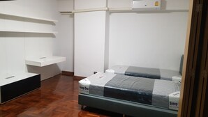 Ein Schlafzimmer mit einem Bett, einem Nachttisch, einem Kleiderschrank und einem kleinen Schreibtisch.