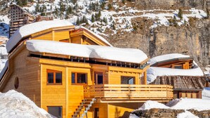 Un chalet in legno con un balcone, immerso nella neve.