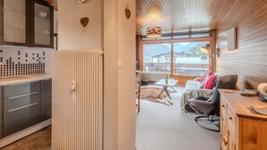 A modern kitchen with a built-in refrigerator, a wooden ceiling, and a large window offering a mountain view. - 3-room apartment 5 min from Morzine center (Morzine)