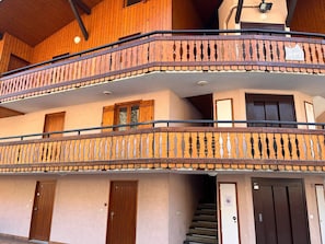 A multi-story building with wooden balconies, a staircase, and doors. - Charming apartment at Morzine slopes with wifi (Morzine)