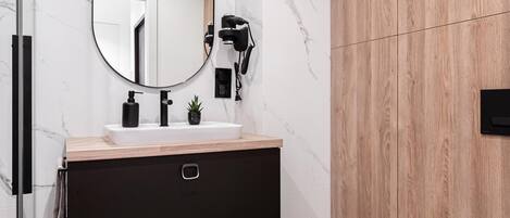 A modern bathroom with a marble backsplash, a wooden panel wall, a black vanity with a mirror, and a white toilet.