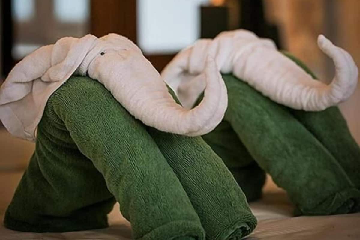 A bed with green pillows shaped like elephants.