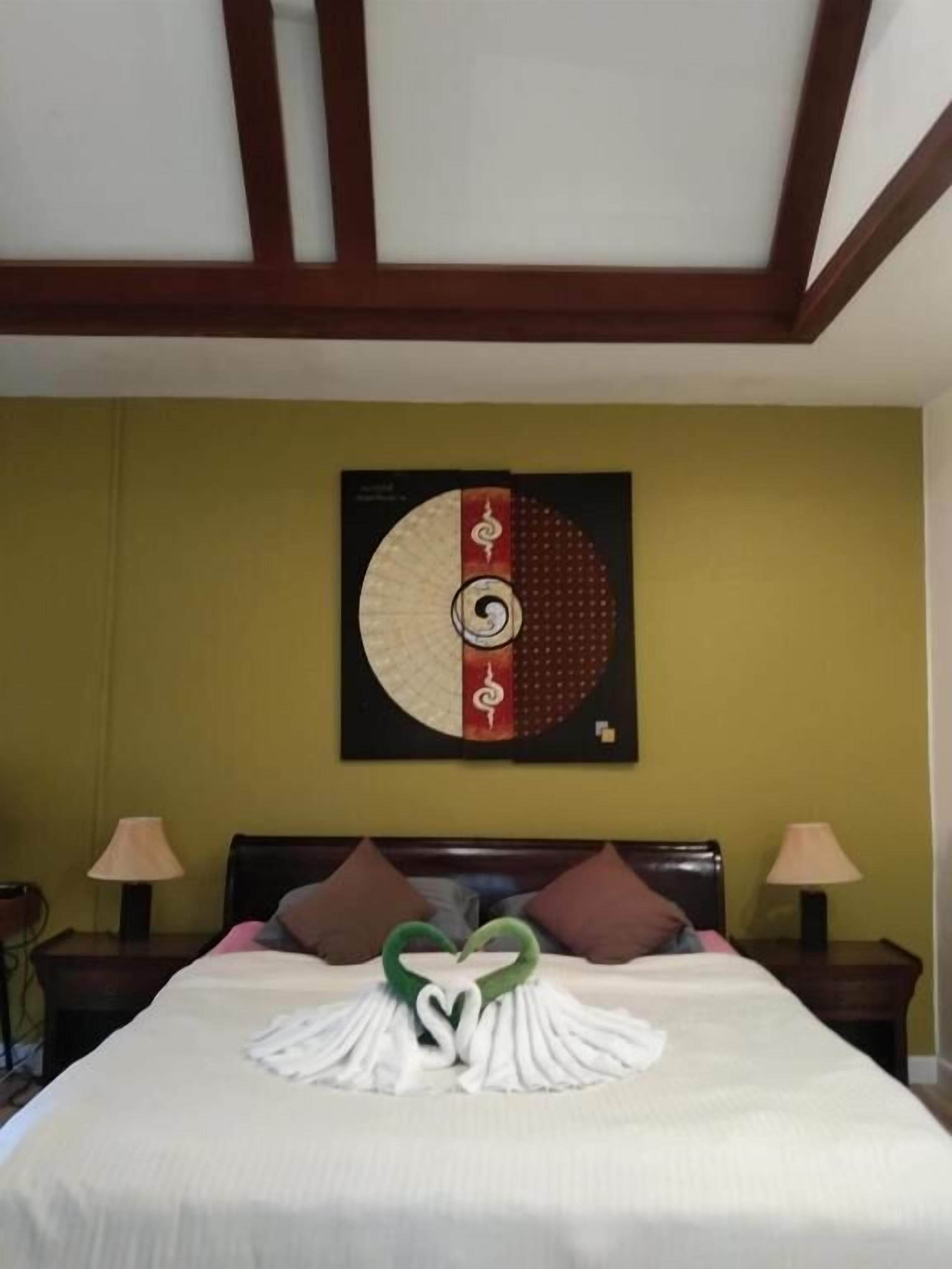 Una habitación de hotel con una cama, una obra de arte en la pared y dos lámparas de noche.