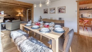 Una mesa de madera dispuesta con platos, vasos y un tazón rojo.