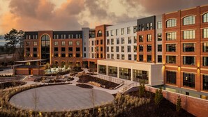 A modern building with multiple floors, large windows, and a central courtyard. - Trilith Guesthouse, Fayetteville, GA, A Tribute Portfolio (Fayetteville)