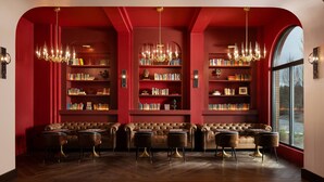 A library with bookshelves, a leather sofa, and a chandelier. - Trilith Guesthouse, Fayetteville, GA, A Tribute Portfolio (Fayetteville)