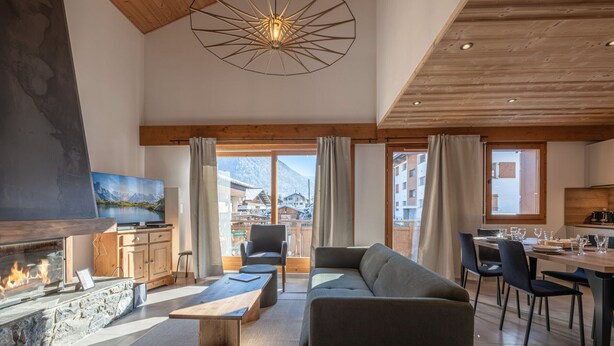 Un salón amplio con chimenea, sofá y mesa de comedor.