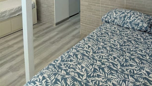 Un dormitorio pequeño con cama, mesita de noche y armario.