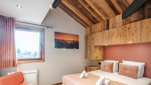 Un dormitorio con cama, una silla, una ventana y un cuadro.