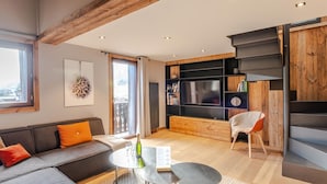 Una sala de estar moderna con un sofá, una mesa de centro y un televisor.