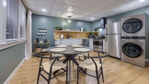 Una cocina moderna con una mesa de comedor redonda, electrodomésticos integrados y un amplio ventanal.