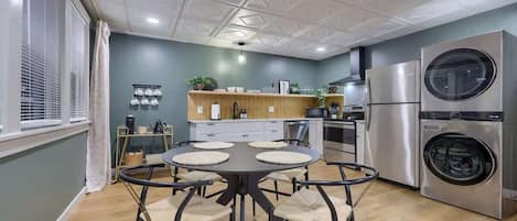 Una cocina moderna con una mesa de comedor redonda, electrodomésticos integrados y un amplio ventanal.