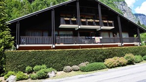A chalet-style building with a balcony, surrounded by lush greenery and mountains. - Cosy T2 apartment with terrace 5 min from Avoriaz cable car (Morzine)