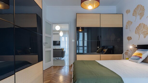 A modern bedroom with a bed, a wardrobe, and a seating area. - Ginkgo House by Wonderful Italy (Turin)