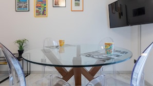 A modern meeting room with a glass table, clear chairs, and framed artwork on the wall. - Ginkgo House by Wonderful Italy (Turin)