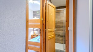 A wooden door leading to a bedroom with a bunk bed and a small bedside table. - Renovated studio-cabin for 4, central Morzine, near slopes (Morzine)