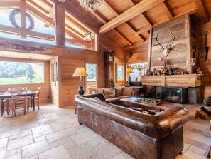 L’intérieur chaleureux d’un chalet en bois comprend un canapé en cuir, une table à manger en bois et une cheminée.