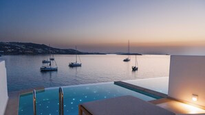 A infinity pool with a view of sailboats on the water. - Icon Mykonos (Mykonos)